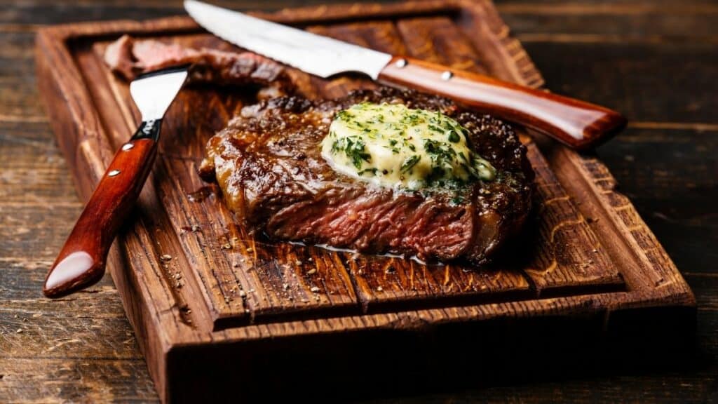 Grilled steak with chive compound butter and blue cheese