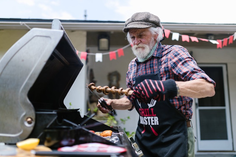 senior grilling food for friends